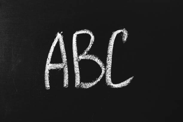 istock AB letters written in white chalk on a black chalkboard. 1206635180
