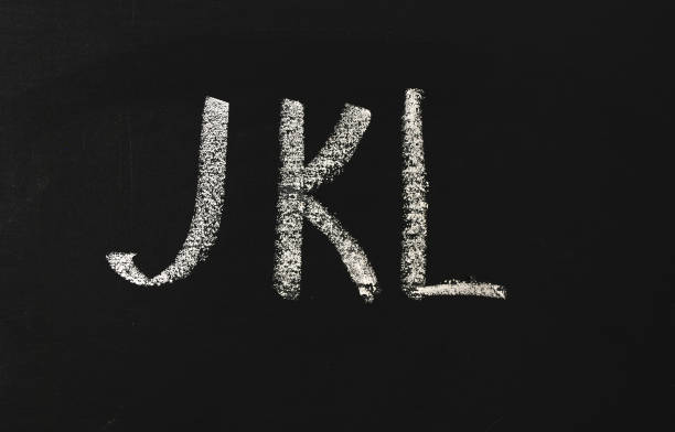 istock JKL alphabet letters written in white chalk on a black chalkboard. 1206635251