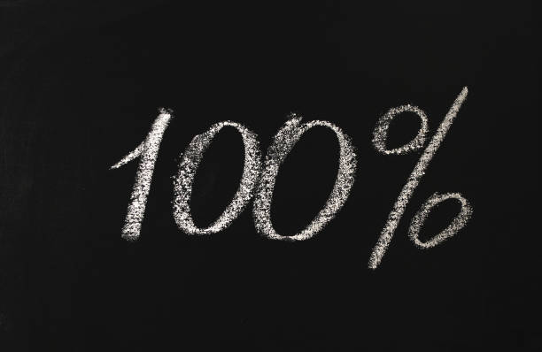 istock Number one hundred percent written in white chalk on a black board. 100% 1206635277
