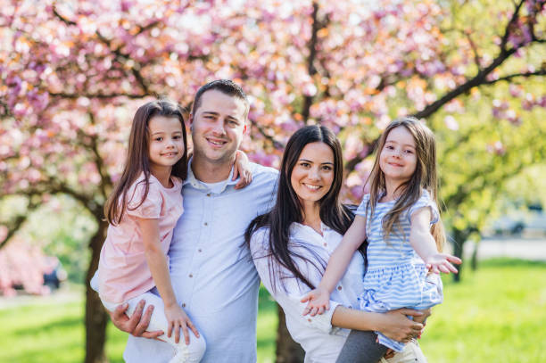 istock Young parents with small daugthers standing outside in spring nature. 1206637996