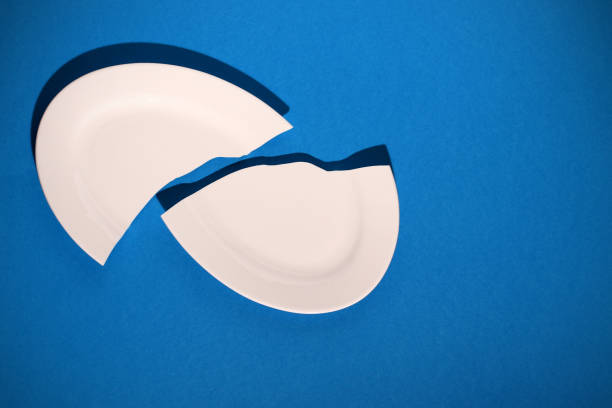 istock broken white porcelain plate on a blue background 1206641333