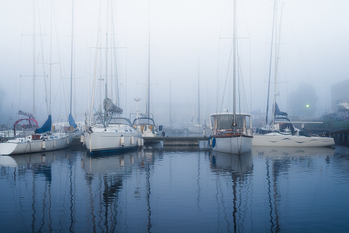 A view of the yacht marina in a strong morning fog at sunrise. Daugava river, port of Riga, Latvia