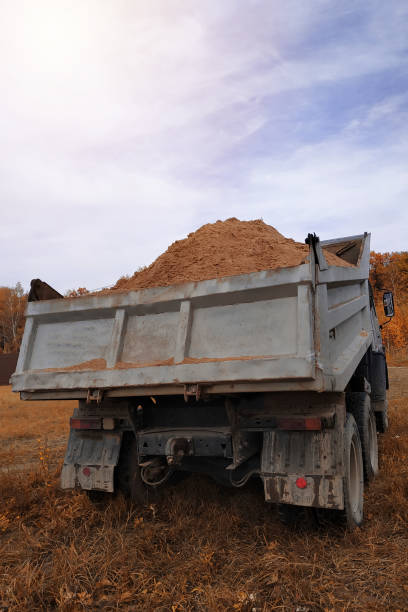 istock A dump truck unloads sand in the construction site. 1206643618