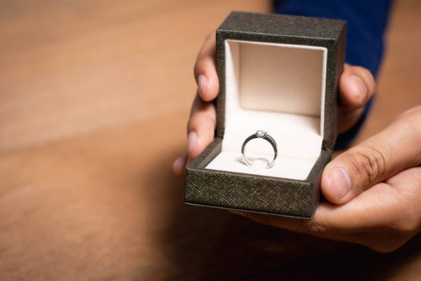 istock Close up of man hands holding ring box with wedding ring. 1206645370