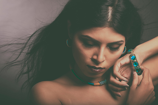 Young India Lady with contemporary jewelry and ear rings in low light and subtle expressions