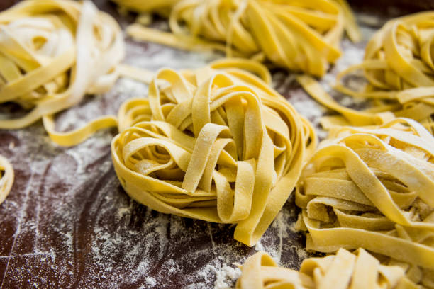 huisgemaakte pasta op een houten achtergrond. italiaanse keuken. restaurant. - zelfgemaakt stockfoto's en -beelden