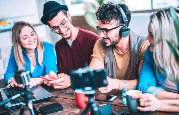 Young friends sharing content on streaming platform with web cam - Startup marketing concept with millenial guys and girls having fun vlogging video feeds on social media networks - Azure filter
