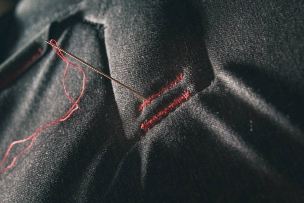 istock Red thread sewed on gray fiber 1206648724