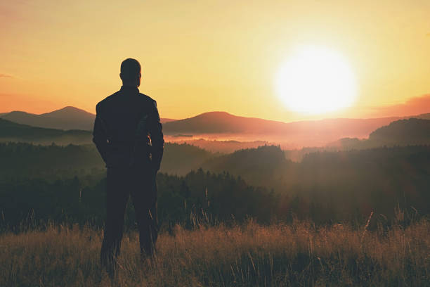 istock Man watch amazing sunrise from heather hill side 1206650455