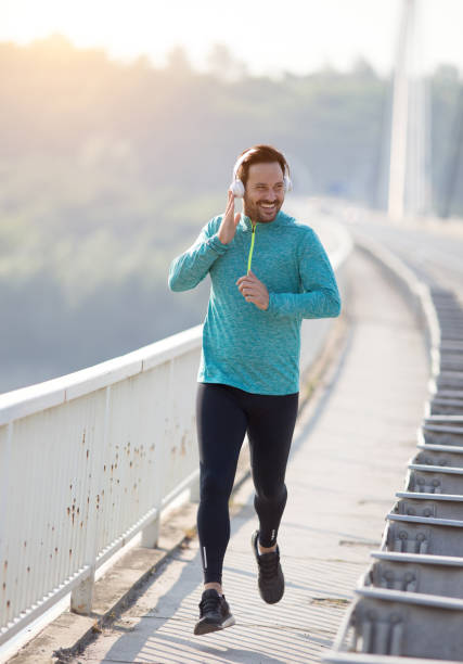 istock Jogger with headphones running on bridge 1206650475