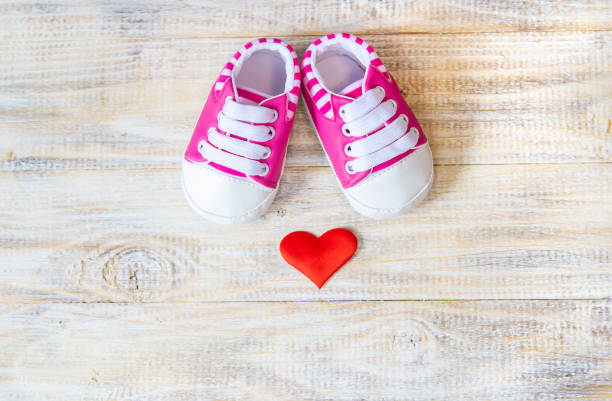 istock Baby booties and heart on a light background. Selective focus. 1206655779