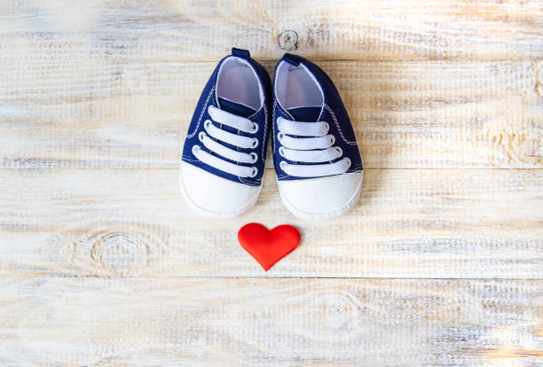 istock Baby booties and heart on a light background. Selective focus. 1206655823
