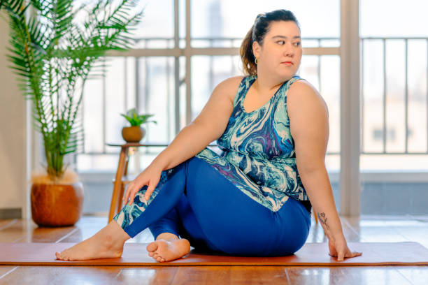 mujer joven practicando yoga en casa - twist baile fotografías e imágenes de stock