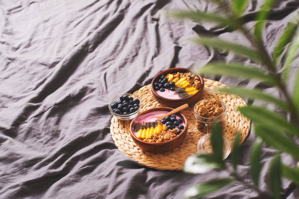 istock Breakfast on bed with smoothie bowl with granola, mango, yogurt and blueberry 1206657515