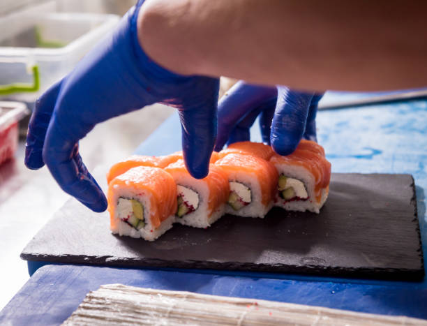 istock Process of making sushi and rolls at restaurant kitchen. Chefs hands with knife. 1206658895