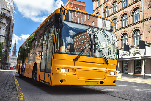 Yellow city bus on historic street of Copenhagen