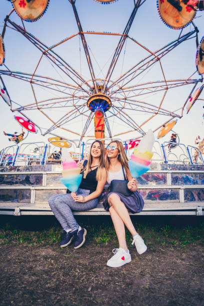 istock Female friends at amusement park 1206659072