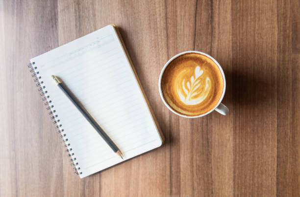 istock cup of latte art coffee with blank notebook and pencil 1206661736
