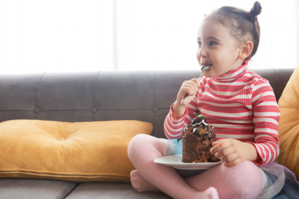 istock Cute little girl eating chocolate cake 1206662749