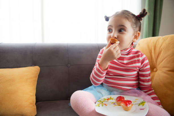 istock Little girl eating cake 1206662925