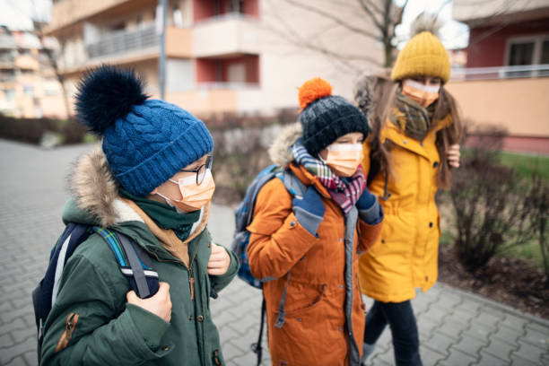 three kids wearing anti virus masks going to school - medium shot imagens e fotografias de stock