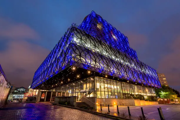 Photo of The lit library of Birmingham at night with its interesting architecture