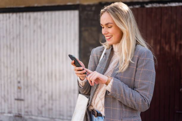 istock Young woman using a mobile phone outdoors stock photo 1206665322