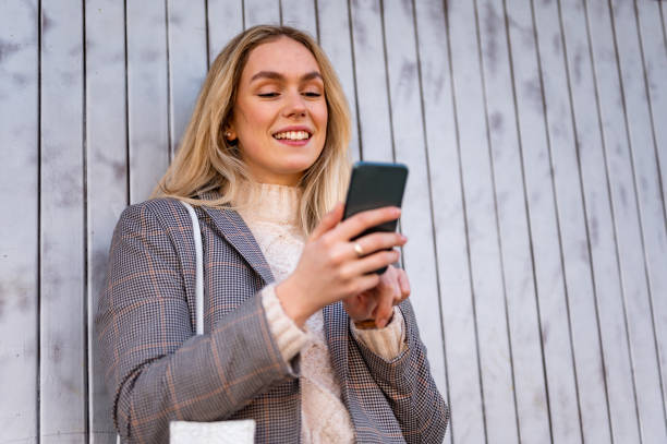 istock Young woman using a mobile phone outdoors stock photo 1206665375
