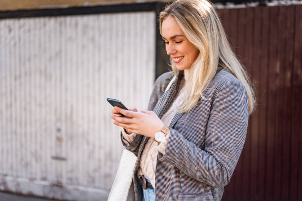 istock Young woman using a mobile phone outdoors stock photo 1206665409