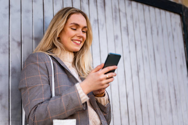 istock Young woman using a mobile phone outdoors stock photo 1206665449
