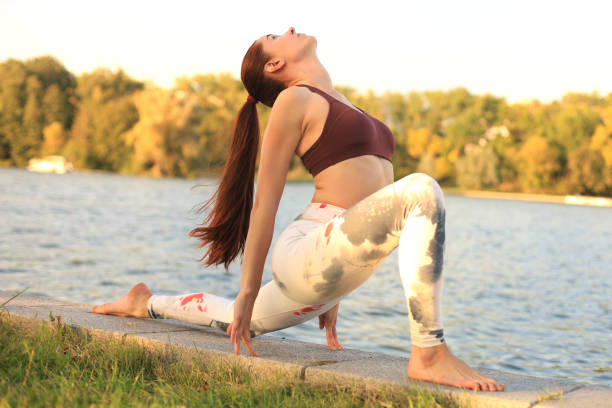 młoda ruda sport kobieta zrobić rozciąganie jogi ćwiczenia na świeżym powietrzu. - 7047 zdjęcia i obrazy z banku zdjęć