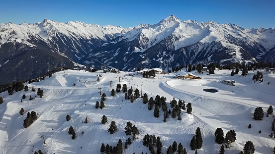 Aerial view of skiers on ski slopes in Penken area, Mayrhofen ski resort, Tyrol, Austria.