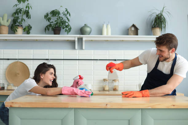 istock Young happy couple is having fun while doing cleaning at home. 1206670335