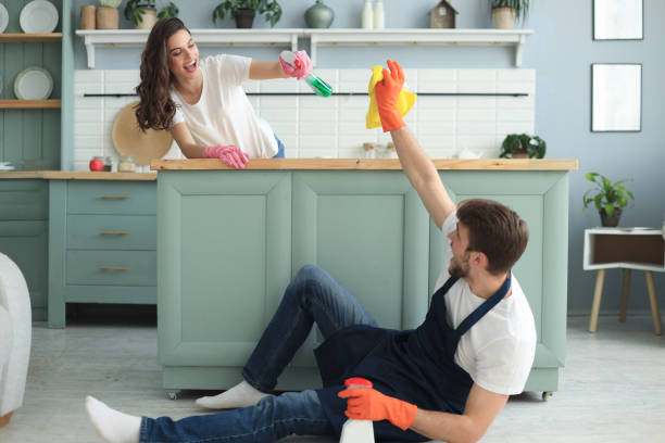 istock Young happy couple is having fun while doing cleaning at home. 1206671486