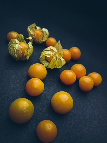 High angle view of Cape Gooseberries placed on black background.