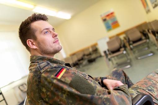 German soldier sits in a classroom . German word Bundeswehr, means german army.