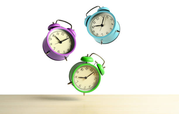 istock Multicolored alarm clocks flying over the table isolated on white background. 1206672951