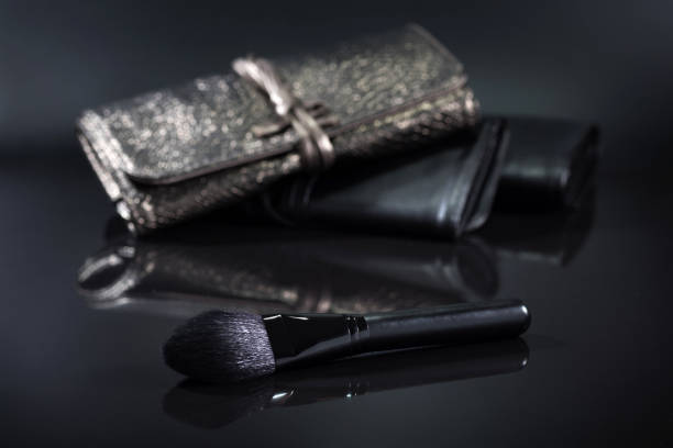 Black brush for a make-up on a black background. Cosmetic set.