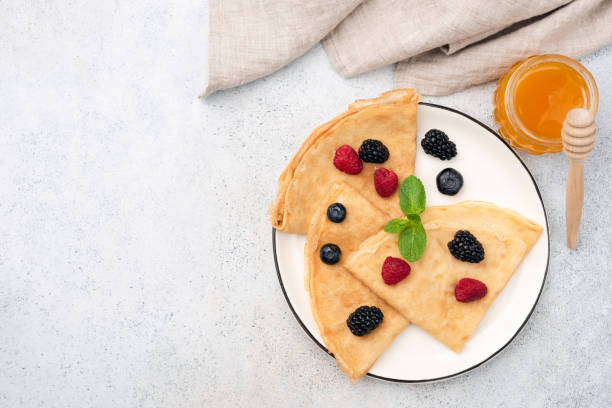 istock French Crepes With Summer Berries And Honey On Plate 1206677346