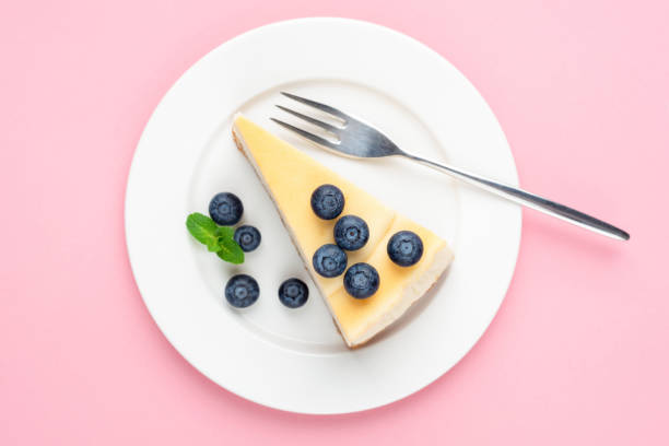 istock Cheesecake with blueberries on pink background 1206677371