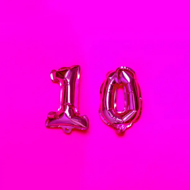 Photo of 10 number helium balloon on a pink background. Congratulation.