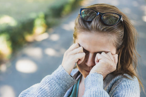 istock Woman with headache rubbing her eyes outside 1206682142