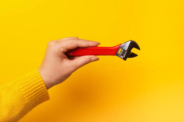 istock red wrench in female hand 1206685323