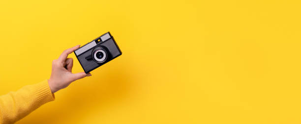 istock Woman's hand holds an old film camera 1206685324
