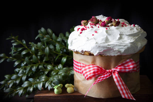 istock Easter, easter bread and green branches. Easter orthodox sweet cake, kulich  covered meringue  and decorated of dryed  rose flowers. Easter decoration 1206687653