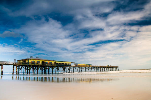 istock Sunglow pier Daytona beach before storm with water reflection 1206693189
