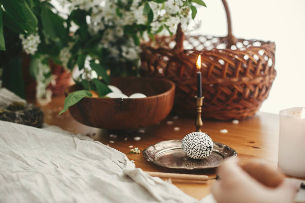 istock Stylish Easter egg with modern wax ornaments and natural dyed eggs on rustic wooden table with spring flowers, basket, candle, linen cloth. Zero waste. Easter Stylish Rural still life. 1206694036