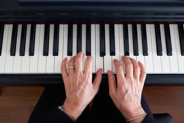 Old woman's hands playing the piano.