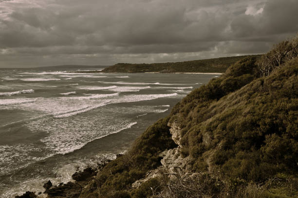 Stunning layered ocean waves crash against rugged cliffs along Australia’s Great Ocean Road. Captured under natural daylight, this dramatic coastal landscape showcases the turquoise waters of the Southern Ocean and the iconic Australian coastline. Perfect for travel, nature, and landscape imagery.