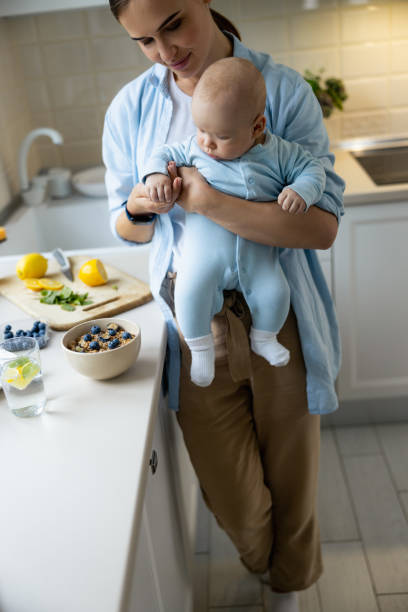 istock Smiling mother standing with her baby in the kitchen 1206701592